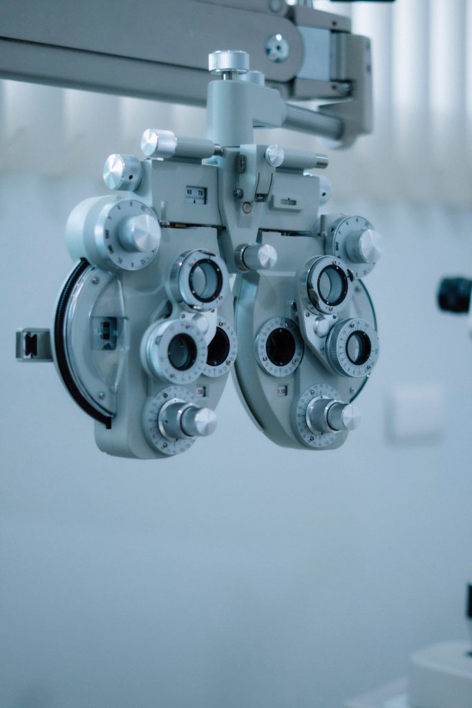 Vue détaillée d'un phoroptère utilisé lors des examens de la vue dans un cabinet d'optométrie, mettant en valeur la précision et la technologie.