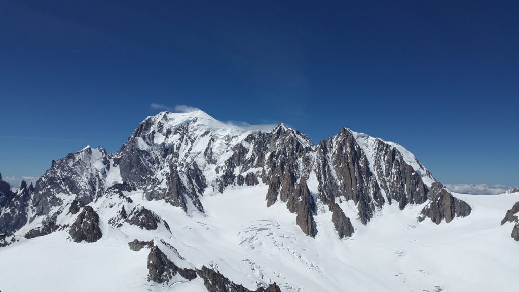 Breathtaking view of snow-covered mountain peaks against a bright blue sky.